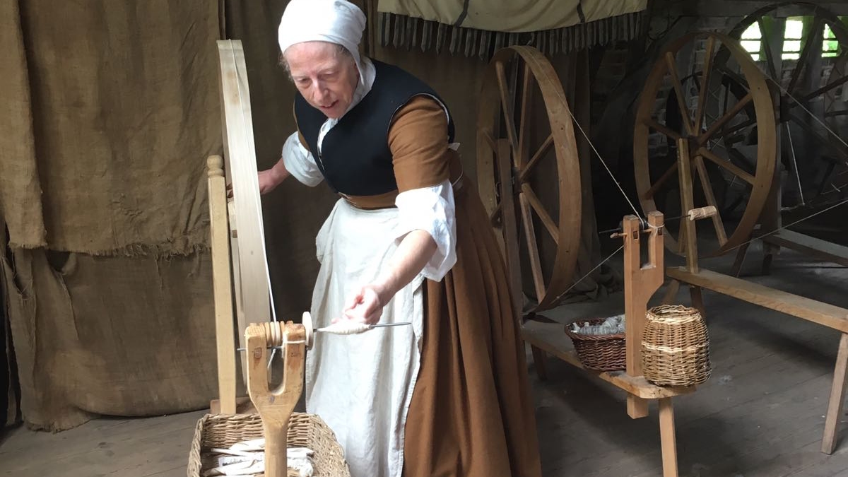 Ruth Bramley in Tudor goodwife clothing with spinning machine.