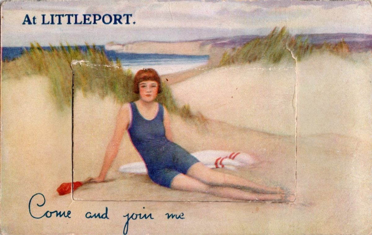A colour postcard of a woman sat on a beach at Littleport (despite it not being beside the sea).
